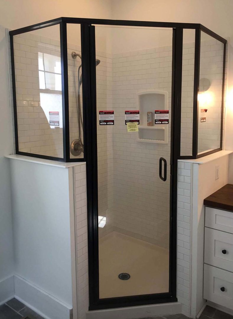 custom glass neo-angle shower enclosure on knee wall with header bar with u channel